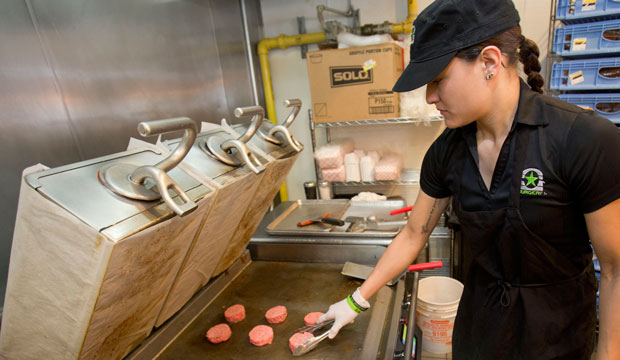 Employee Elia Carranza grills burgers at BurgerFi restaurant in Aventura, Florida, on January 27, 2015. (AP/Wilfredo Lee)