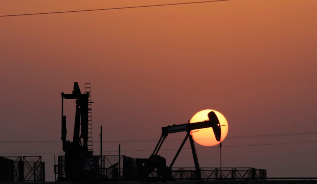 An oil pump works at sunset on September 30, 2015, in the desert oil fields of Sakhir, Bahrain. (AP/Hasan Jamali)
