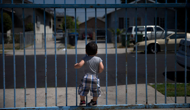 One-year-old Joshua Tinoco, who has been declared an immigration enforcement priority for the United States, clings to a gate at his relative's home in Los Angeles. (AP/Jae C. Hong)