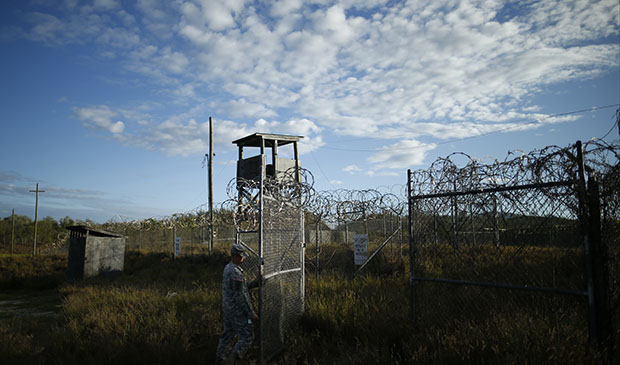 In this photo reviewed by the U.S. military, a soldier closes the gate at the now abandoned Camp X-Ray, which was used as the first detention facility for Al Qaeda and Taliban militants captured after the September 11 attacks at Guantanamo Bay Naval Base, Cuba, November 2013. (AP/Charles Dharapak)