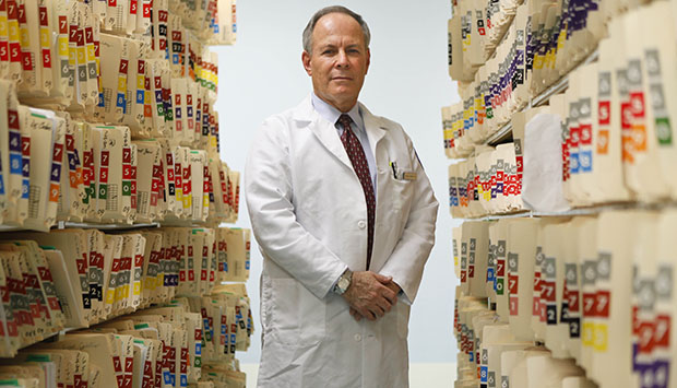 A doctor poses for a picture among patient files at a New York hospital, June 2009. (AP/Seth Wenig)