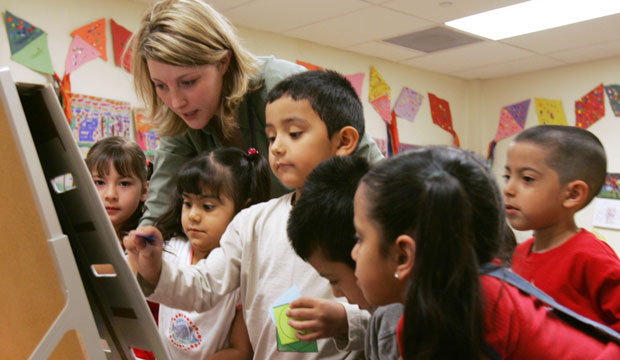 A preschool teacher works with students at the Shiloh School in downtown Waukegan, Illinois, April 2006. (AP/Charles Rex Arbogast)