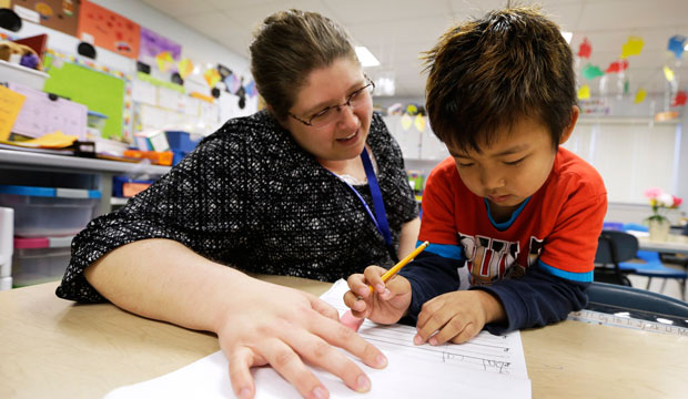 Elementary school teacher works with a kindergarten student in Columbus Junction, Iowa. (AP/Charlie Neibergall)