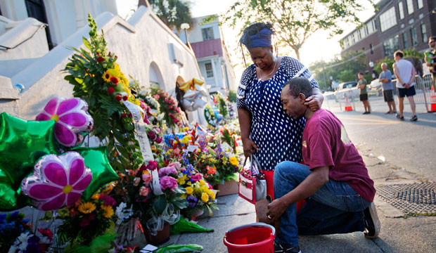 Allen Sanders kneels next to his wife Georgette as they pray at a sidewalk memorial in memory of the Mother Emanuel shooting victims on June 20, 2015, in Charleston, South Carolina. (AP/David Goldman)