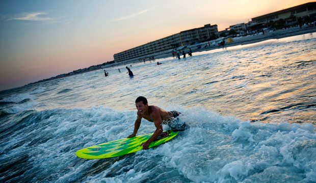 A surfer paddles out in Folly Beach, South Carolina, where the City Council passed a resolution opposing seismic surveying and offshore drilling on March 10, 2015. (AP/David Goldman)