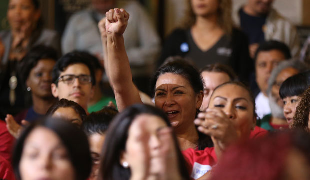 Workers react as the Los Angeles City Council votes to raise the city's minimum wage to $15 per hour by 2020 on May 19, 2015. (AP/Damian Dovarganes)