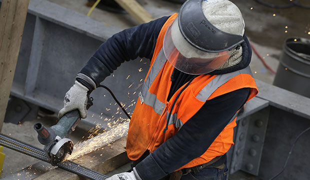 Sparks fly as a construction worker uses a grinder to cut through steel reinforcing bars, February 1, 2016, in New York. (AP/Mark Lennihan)