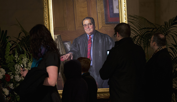 People look at a portrait of Justice Antonin Scalia displayed near his casket in the Great Hall of the Supreme Court in Washington, February 19, 2016. (AP/Manuel Balce Ceneta)