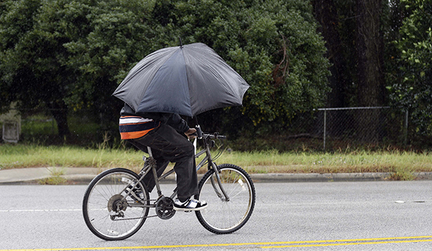 A bicyclist shields himself against the rain in Marion, South Carolina, October 4, 2015. (AP/Gerry Broome)