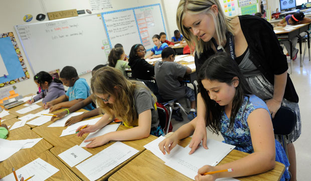 A teacher helps her student with a language arts lesson in October 2013. (AP/Steve Ruark)