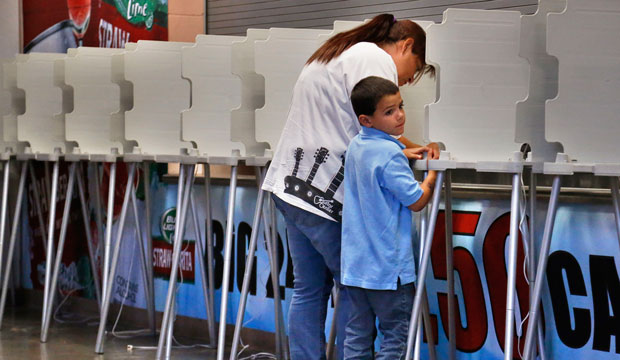 A woman completes her ballot at a polling station in Pueblo, Colorado, in 2013. (AP/Brennan Linsley)