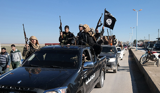 Islamic State militants pass by a convoy in Tel Abyad, northeast Syria, May 2015, in an AP-verified photo from a militant website. (Militant website via AP)