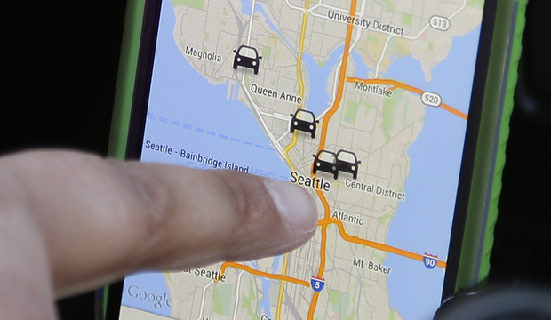 A driver for the ridesharing service Lyft uses Lyft's smartphone app to see where other drivers working at the same time are located so she can plan the best place to wait for customers, March 2014. (AP/Ted S. Warren)