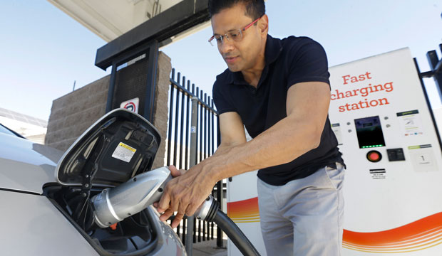 Darshan Brahmbhatt plugs a charger into his electric vehicle at the Sacramento Municipal Utility District charging station in Sacramento, California, on September 17, 2015. (AP/Rich Pedroncelli)