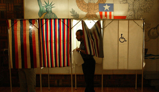 Faisel Mohamed leaves a voting booth at the Holbrook Cafe in Hamtramck, Michigan, on July 20, 2004. (AP/Paul Sancya)