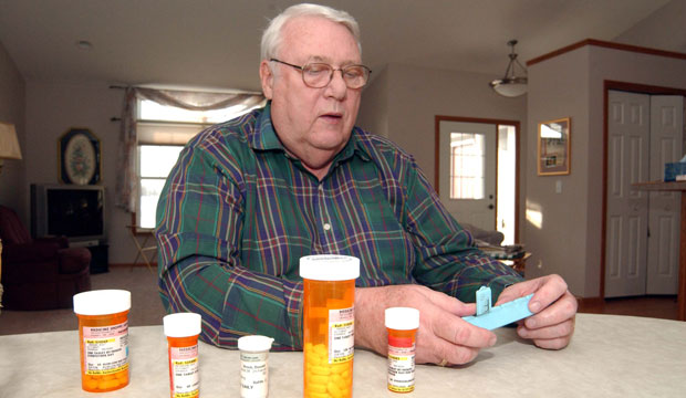 A man looks at his prescription medications at his home in Litchfield, Minnesota, in 2006. (AP/Bill Zimmer)