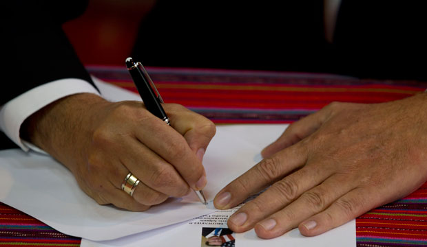 Commissioner of CICIG, Ivan Velasquez, writes at a press conference, March 2016. (AP/Moises Castillo)