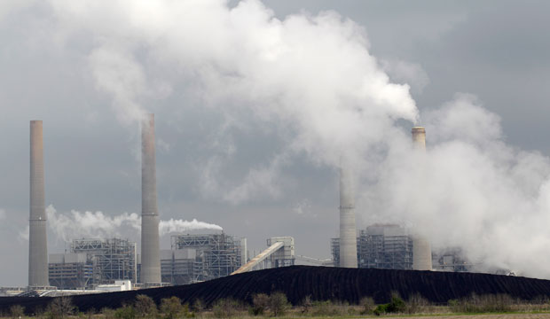 Exhaust rises in front of piles of coal at NRG Energy Inc.'s W.A. Parish Electric Generating Station in Thompsons, Texas, in March 2011. (AP/David J. Phillip)