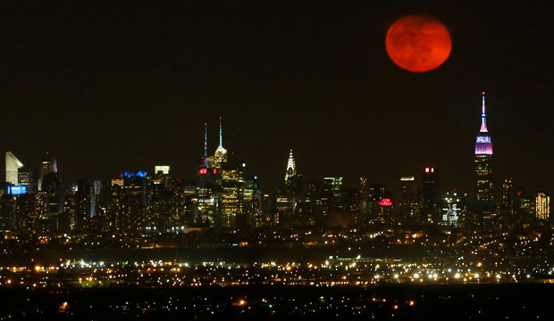The moon rises in its waning period over the New York City skyline seen from West Orange, New Jersey, April 5, 2015. (AP/Julio Cortez)