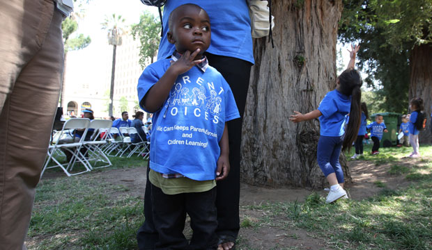 Peter Yabadi, age 2, stands next to his mother, Bernadette Yabadi, at a rally calling for increased child care subsidies at the Capitol in Sacramento, California, on May 6, 2015. (AP/Rich Pedroncelli)