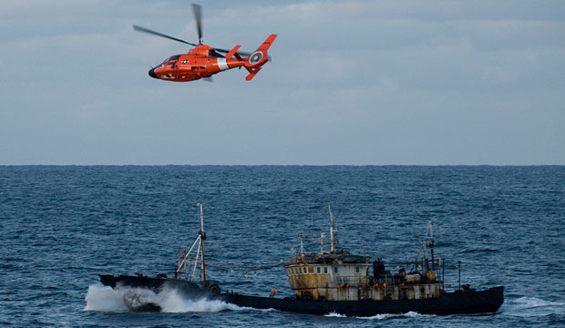 A U.S. Coast Guard helicopter patrols over a Chinese-registered fishing vessel after it was suspected of illegal fishing in the northern Pacific Ocean. (U.S. Coast Guard/Jonathan R. Cilley)