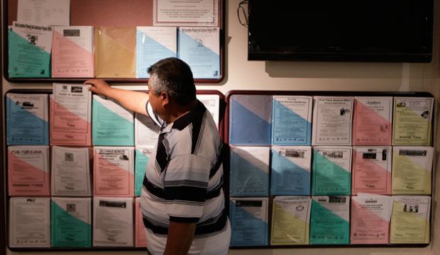 Jobseeker Jose Rodriguez looks for employment opportunities at the Metro North WorkSource Center in Los Angeles on January 6, 2011. (AP/Damian Dovarganes)