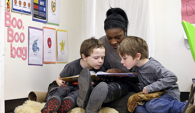 An assistant teacher reads to students at a pre-K school in Seattle, February 12, 2016. (AP/Elaine Thompson)