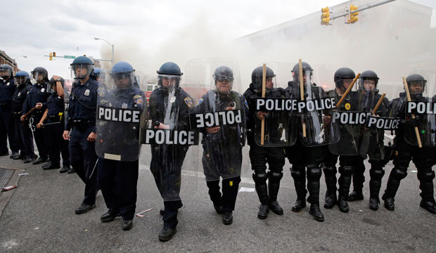 Police advance toward protestors as a store burns following the funeral of Freddie Gray on April 27, 2015, in Baltimore. (AP/Patrick Semansky)