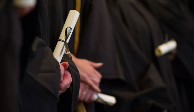 Graduates hold their diplomas during commencement exercises in May 2014. (AP/Gretchen Ertl)