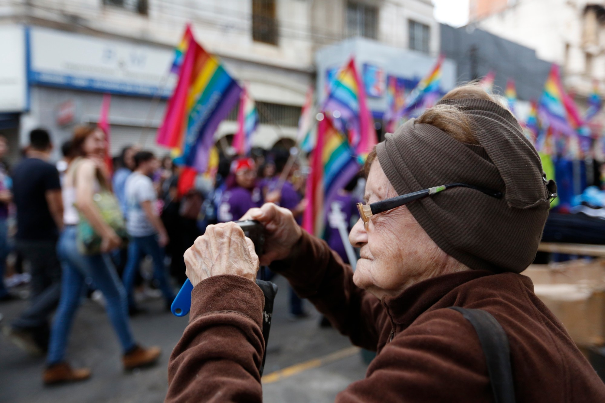 An elderly woman takes pictures of a gay pride parade on July 9, 2016. (AP/Jorge Saenz)