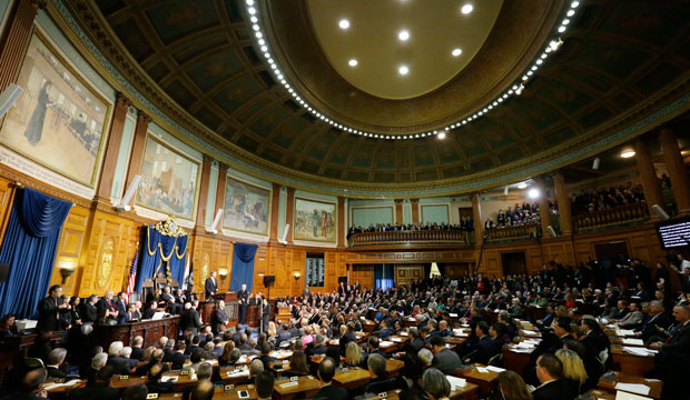 Massachusetts Gov. Charlie Baker, at podium left, delivers his inaugural speech after taking the oath of office, January 8, 2015, in the House Chamber of the Statehouse in Boston. (AP/Steven Senne)