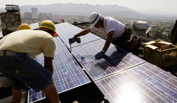 Installers install solar electrical panels on the roof of a home in Glendale, California, March 2010. (AP/Reed Saxon)