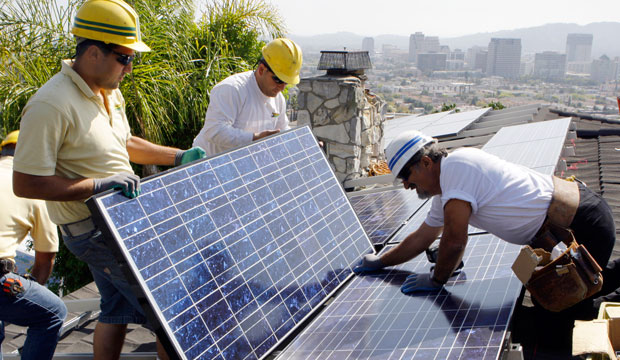 Workers install solar electrical panels on the roof of a home in Glendale, California, on March 23, 2010. (AP/Reed Saxon)
