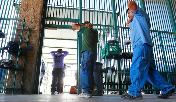 Suspected unauthorized immigrants are transferred out of a holding area at the U.S. Customs and Border Protection headquarters in Tucson, Arizona, on August 9, 2012. (AP/Ross D. Franklin)