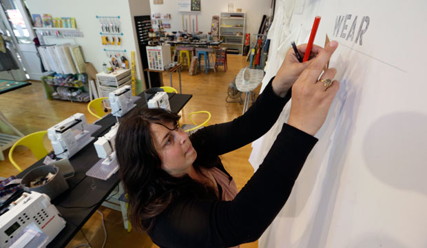 Keli Faw puts up a display in her shop, Drygoods Design, in Seattle on July 1, 2015. (AP/Elaine Thompson)