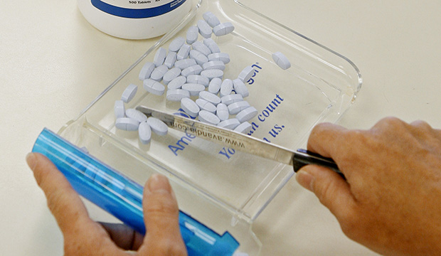 A pharmacy technician poses for a picture with prescription medication at a pharmacy in Edmond, Oklahoma, August 2010. (AP/Sue Ogrocki)