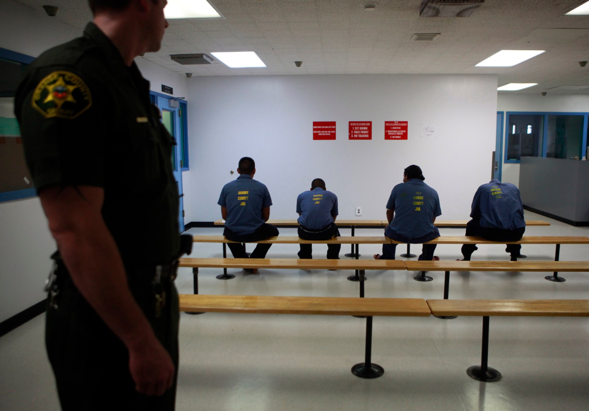 An Orange County Sheriff's deputy keeps a watch over a group of immigration detainees in the medical and dental care area at the Theo Lacy Facility in Orange, Calif., Tuesday, Sept. 28, 2010. Hundreds of detained immigrants are being transferred to Orange County jails, and more are on the way, under a deal with the federal government that would bring the cash-strapped Orange County Sheriff's Department up to $30 million a year, a newspaper reported Sunday. (AP Photo/Jae C. Hong)