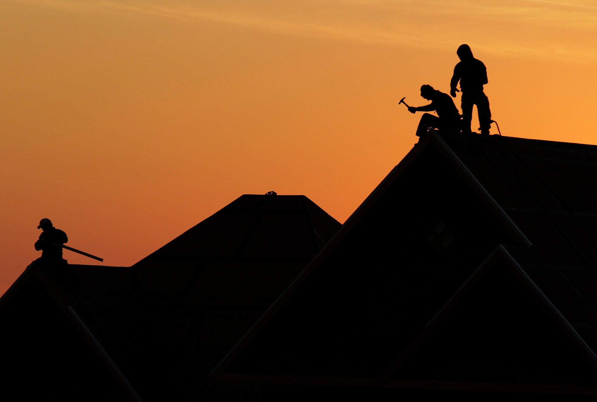 Workers are silhouetted as they build a home in Joplin, Mo., Thursday, Jan. 19, 2012. The city has issued nearly 4,000 building permits to homeowners since the an EF-5 tornado hit on May 22, 2011. (AP Photo/Charlie Riedel)