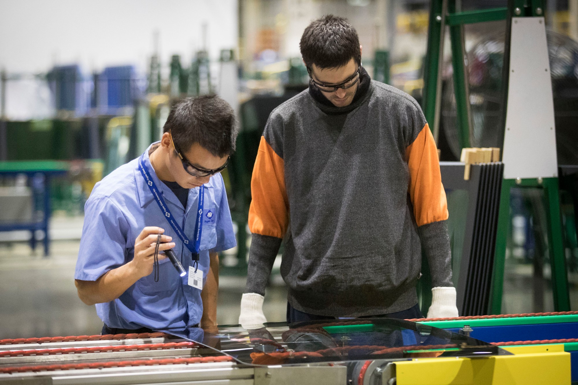 Workers inspect a pane of glass at a plant on October 7, 2016, in Moraine, Ohio.