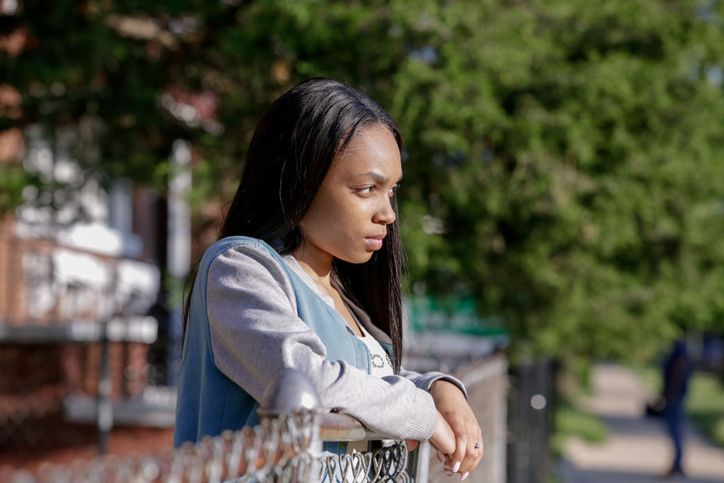 A young woman stands outside her home on the South Side of Chicago, June 8, 2016. (AP/Teresa Crawford)