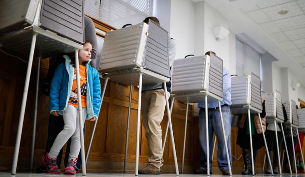 Violet Lay waits beside her mother Susan to finish voting on Election Day, Tuesday, November 8, 2016, in Cincinnati. (AP/John Minchillo)