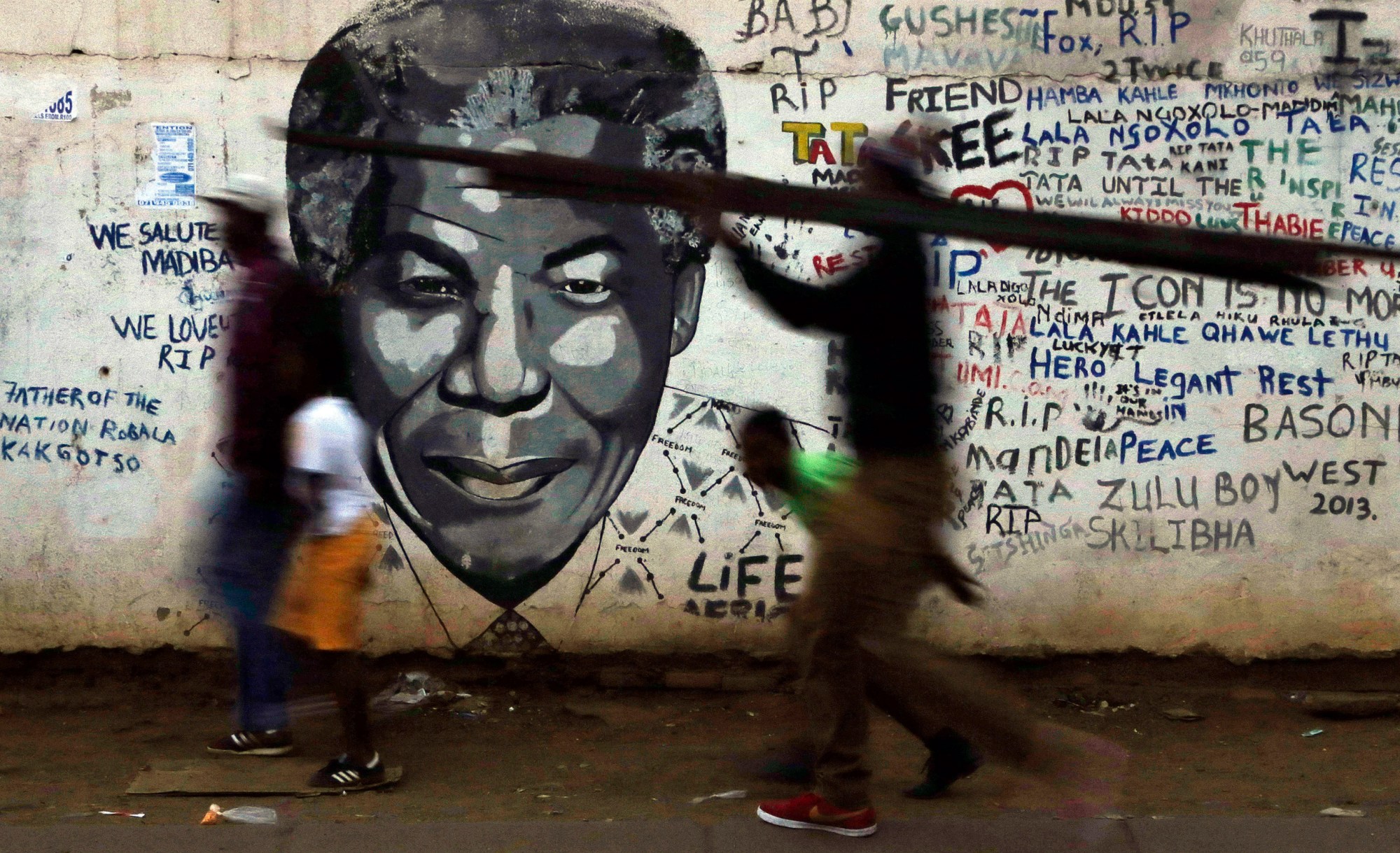 People walk past a mural of former South African President Nelson Mandela in Katlehong, south of Johannesburg, South Africa, May 2015. ((AP/Themba Hadebe))