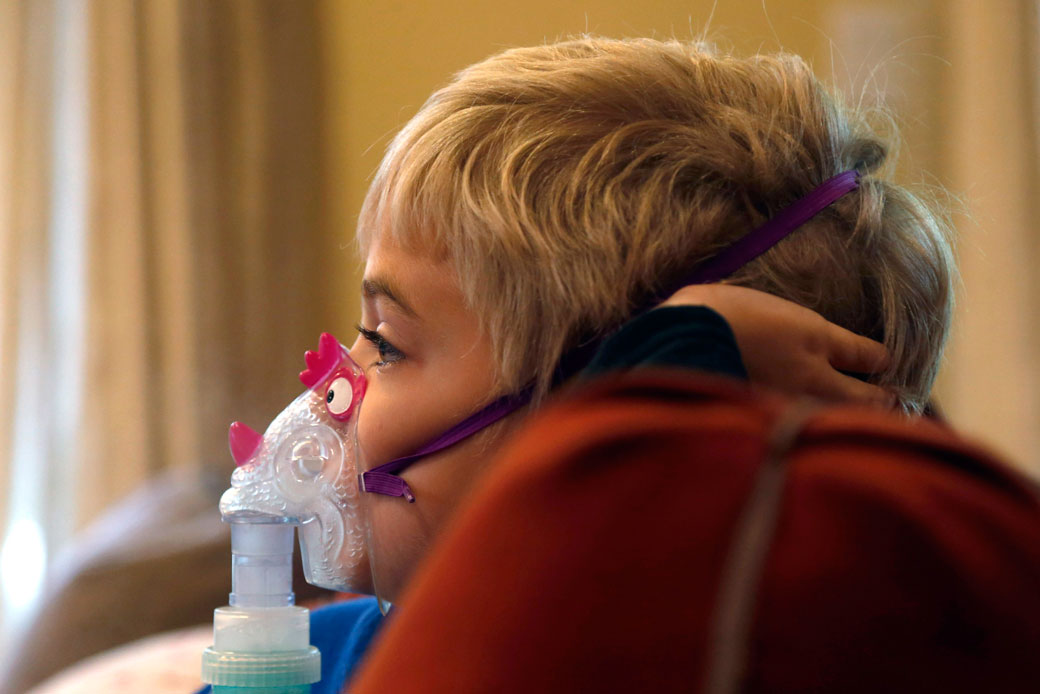 Carter Howard watches a cartoon during his asthma treatment in Northbrook, Illinois, on October 15, 2013. (AP/Charles Rex Arbogast)