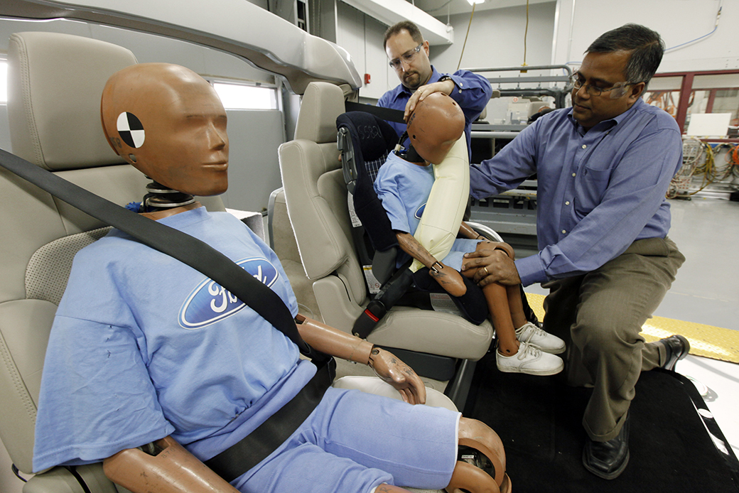 Men adjust a crash dummy with an inflatable seat belt on a demonstrator at Ford Motor Co., November 2009. ((AP/Paul Sancya))