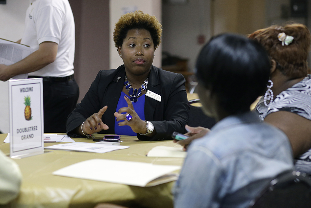 A human resources director talks with job applicants during a job fair, January 2015. ((AP/Lynne Sladky))