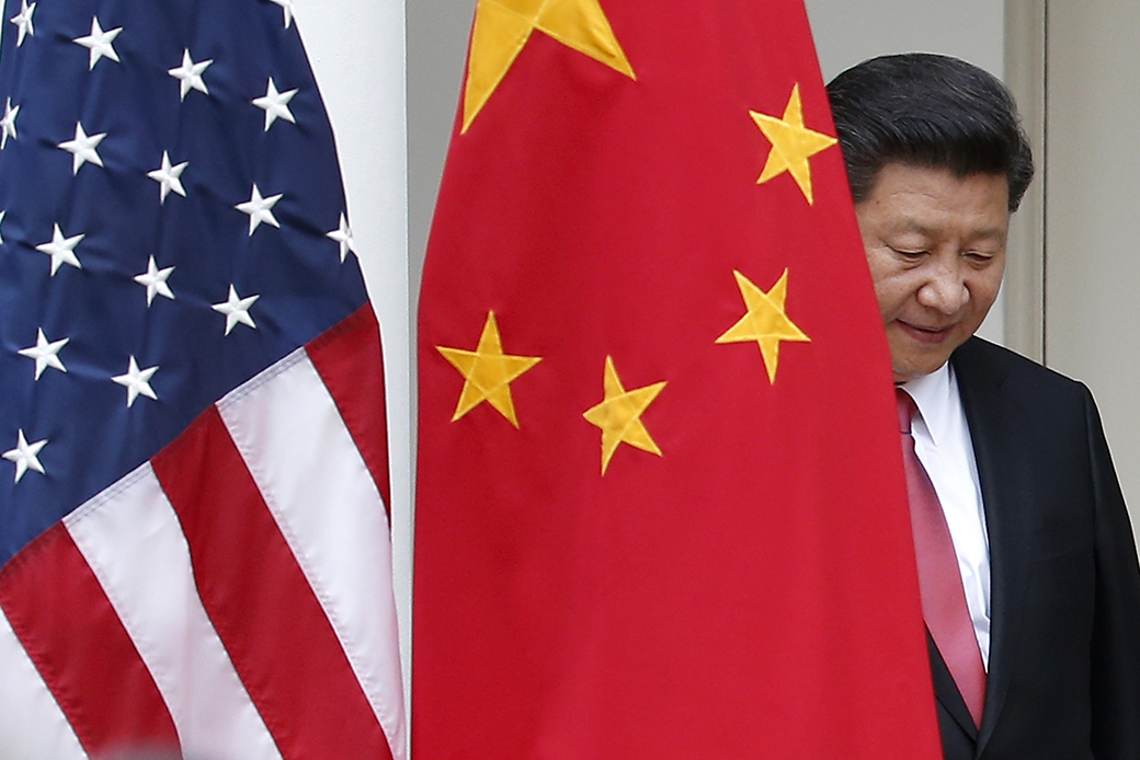 Chinese President Xi Jinping steps out from behind China's flag as he takes his position for a news conference in the Rose Garden of the White House in Washington. ((AP/Evan Vucci))