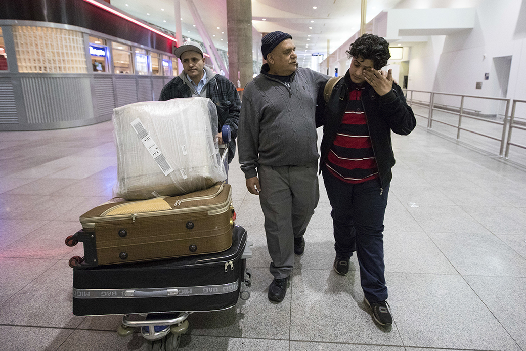 A teenage boy from Yemen wipes his eyes as he walks with his father and his uncle after arrival at John F. Kennedy International Airport in New York, February 5, 2017. ((AP/Alexander F. Yuan))