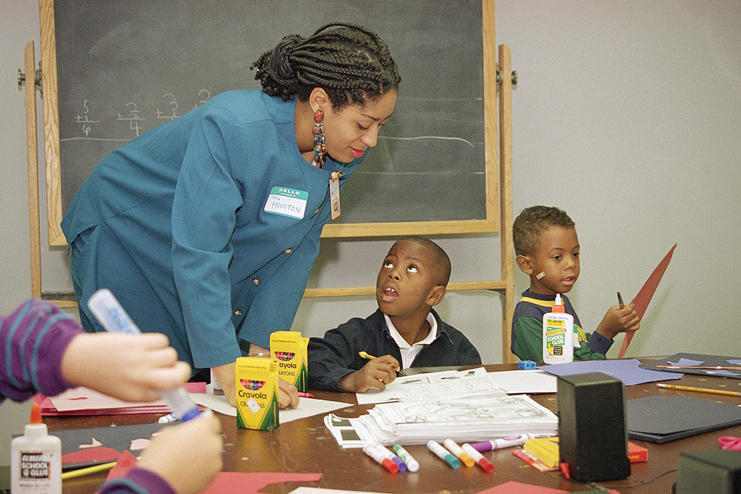 A teacher talks to a student during a class for first-graders at a learning center in Chicago, September 1993. ((AP/Mark Elias))