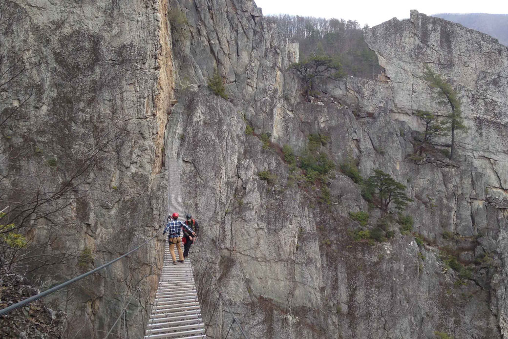 Matt Karlson, right, and Chris Ward, walk across a suspension bridge between rock formations in Circleville, West Virginia, on March 24, 2015. (AP/ Jonathan Drew)