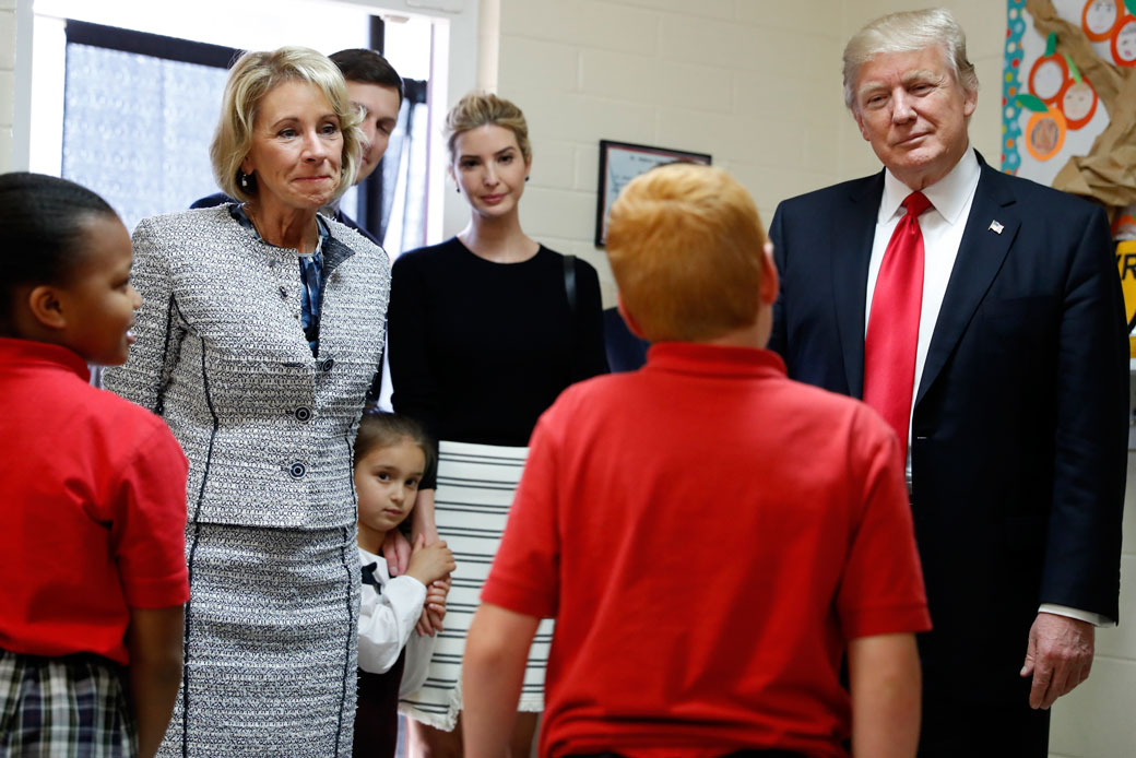 President Donald Trump, Education Secretary Betsy DeVos, his daughter Ivanka, and Janayah Chatelier, 10, left, listen to Landon Fritz, 10, during a tour of Saint Andrew Catholic School, March 3, 2017, in Orlando, Florida. (AP/Alex Brandon)